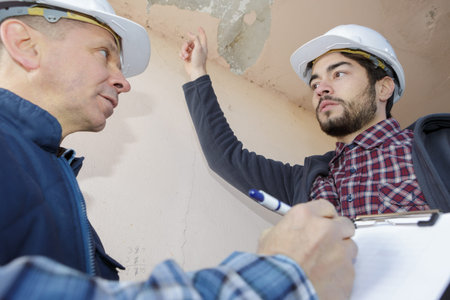 builders inspecting roof damage