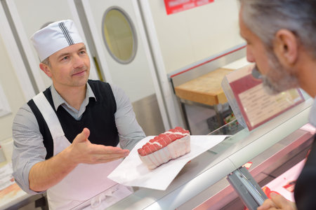male butcher seving a male customer
