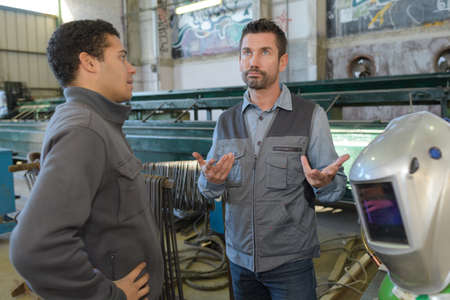 2 welders discussing in the workshopの写真素材