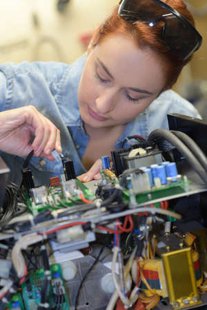 woman fixing a computer at workの写真素材