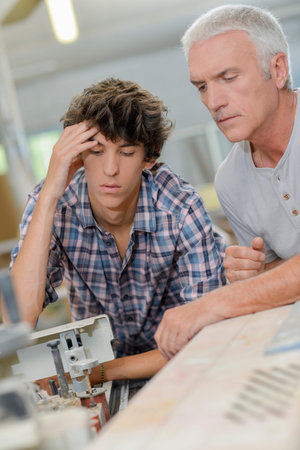 Teenager helping his carpenter dad