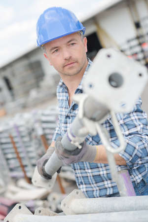 Worker moving scaffolding poleの写真素材