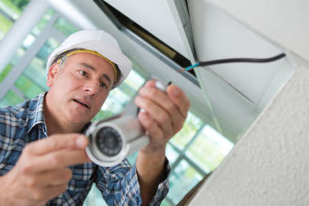 Senior contractor installing surveillance cameraの写真素材