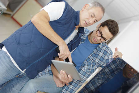 Men looking at table screenの写真素材