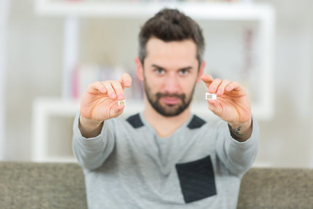 portrait of man holding sim card in each hand