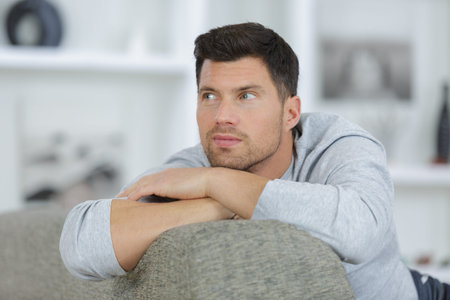 thoughtful young handsome male on a sofaの写真素材