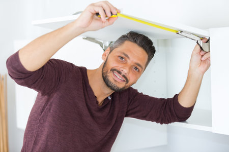 man measuring cupboard doorの写真素材