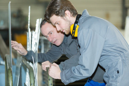 apprentice with tutor looking at sheet metal