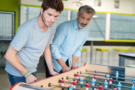 friends having fun together playing table football
