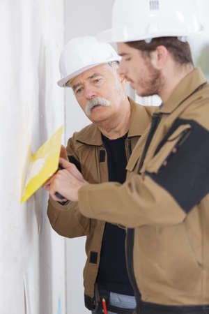 Young builder training with trowelの写真素材