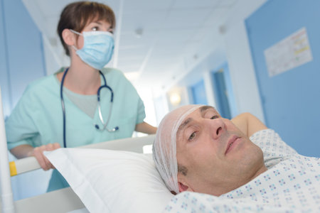 nurse taking patient on gurney into surgeryの写真素材