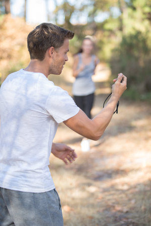 coach and jogger training in the forestの写真素材
