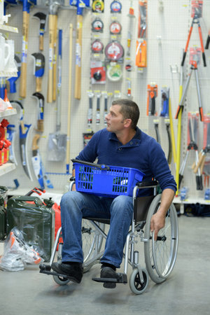 Handicapped man shopping with basket on his lap