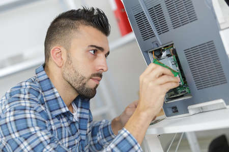 Man replacing battery in applianceの写真素材