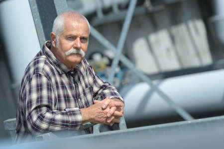 Contemplative senior man on worksiteの写真素材