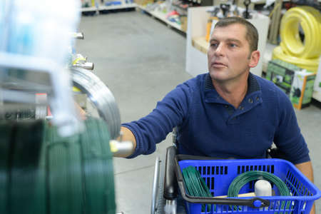 Man in wheelchair shopping in hardware storeの写真素材