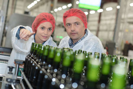 Factory workers looking at bottling plantの写真素材