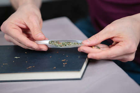 Hands preparaing a cannabis cigaretteの写真素材