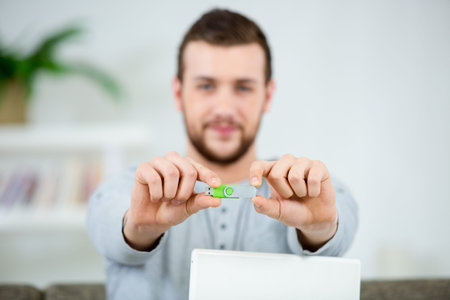 handsome young man showing usb key in his hand