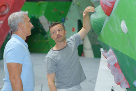 Men looking at indoor climbing structureの写真素材