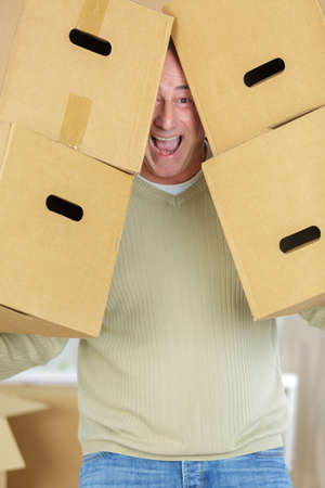 happy man hidding behind boxesの写真素材