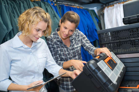 two women looking a tool boxの写真素材