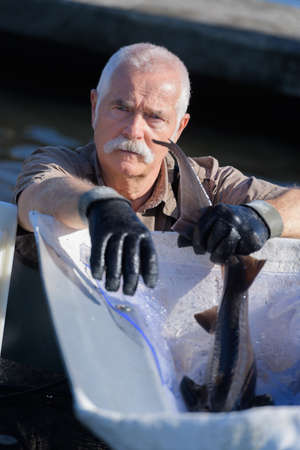 old fisherman catching a fishの写真素材