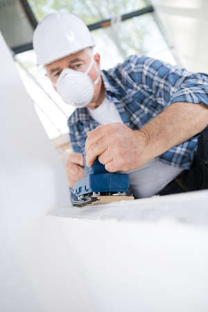 senior builder in helmet working on a wallの写真素材