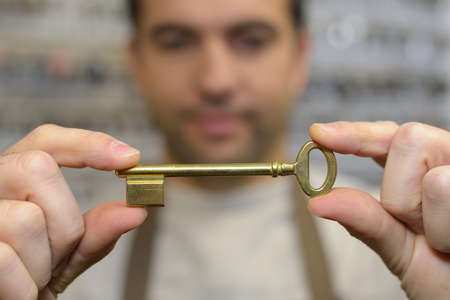 close up of locksmith hands holding keyの写真素材