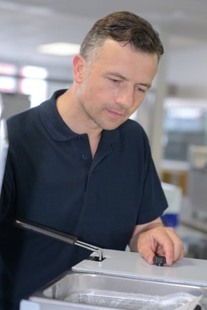 man fixing a deep-fryer
