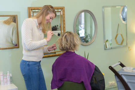 Hairdresser colouring customer's hairの写真素材