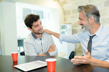 young rofessionals chatting during a coffee breakの写真素材