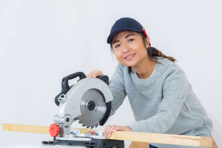 mechanic woman is working with circular sawの写真素材