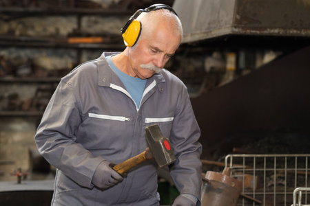 old man sculptor works the quarry