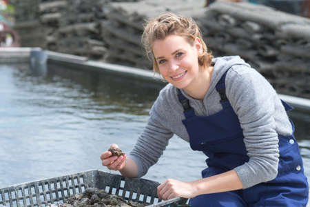 happy femake worker at fish and mussel farmの写真素材