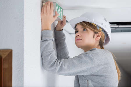young woman builder wearing helmet and holding blank bannerの写真素材