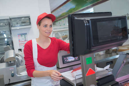pretty butchery woman working in butchery shopの写真素材
