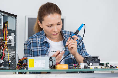 young female pc technician fixing a computerの写真素材