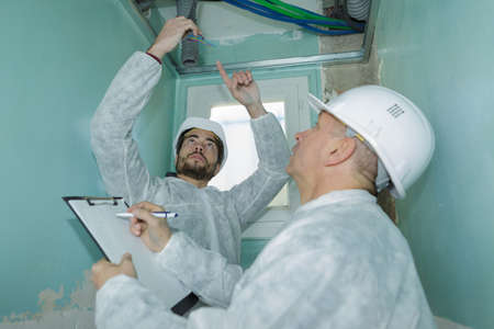 contractor checking water pipes pvc under cement ceilingの写真素材