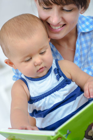 happy mother and baby reading book