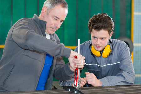 supervisor demonstrating use of tool to apprentice
