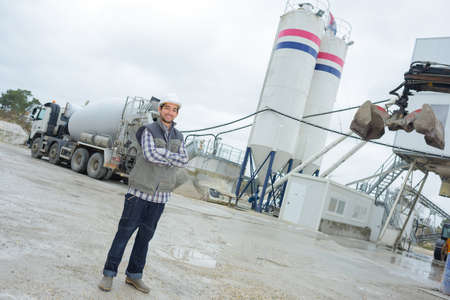 laborer outside a factory working dressed with safety overalls equipmentの写真素材