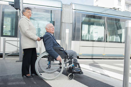 senior woman pushing man in wheelchairの写真素材
