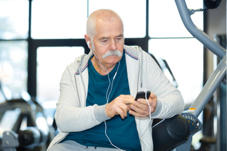senior man preparing music on his cellphone to exercise with