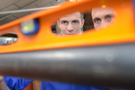 View of builders through handle in spirit levelの写真素材