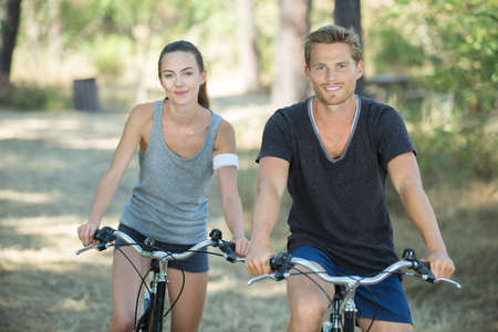young couple cycling in forestの写真素材