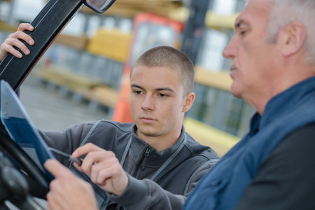 instructor teaching apprentice how to drive a heavy construction vehicle