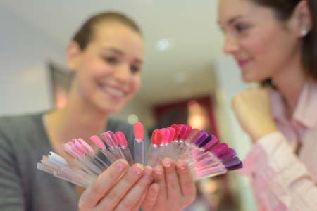 woman thinking about the nail polish shade of her manicureの写真素材