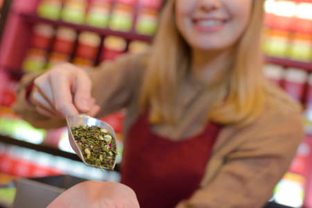 woman showing tea at tea storeの写真素材