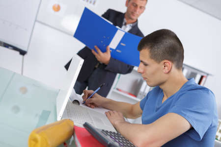 male home tutor helping boy with studiesの写真素材